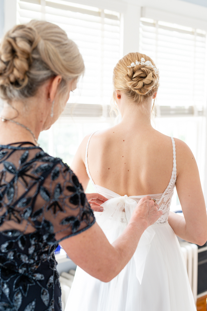 Bride with mom helping her getting ready in her Frederick, MD bridal suite