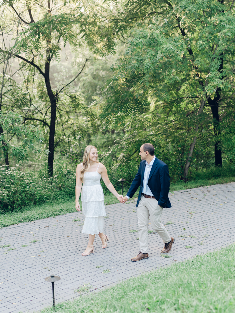 Mac and Abbey walking through the gardens during their engagement session at Howard County Conservancy