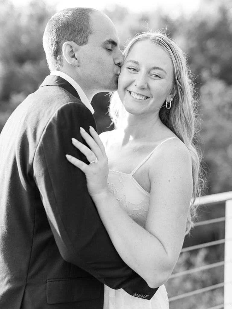 Mac kissing Abbey on the cheek during their engagement session at Howard County Conservancy