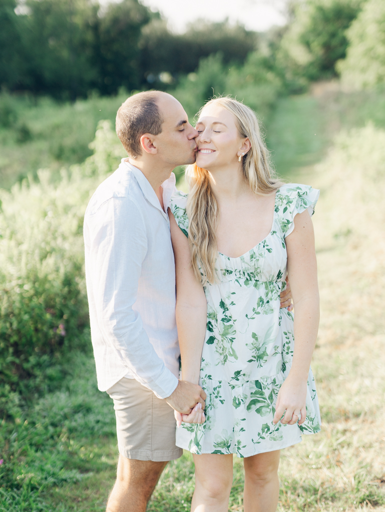 Mac kissing Abbey on the cheek during their engagement session at Howard County Conservancy