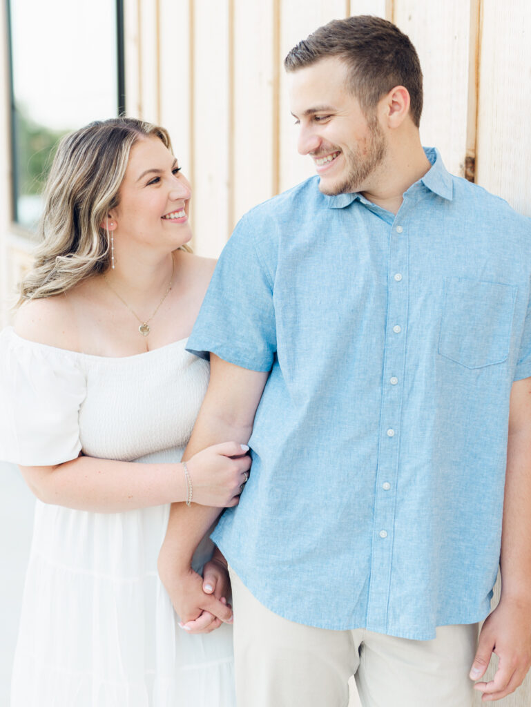 Casey and Giovanni laughing with each other near the barn at Bortner Valley during their engagement session