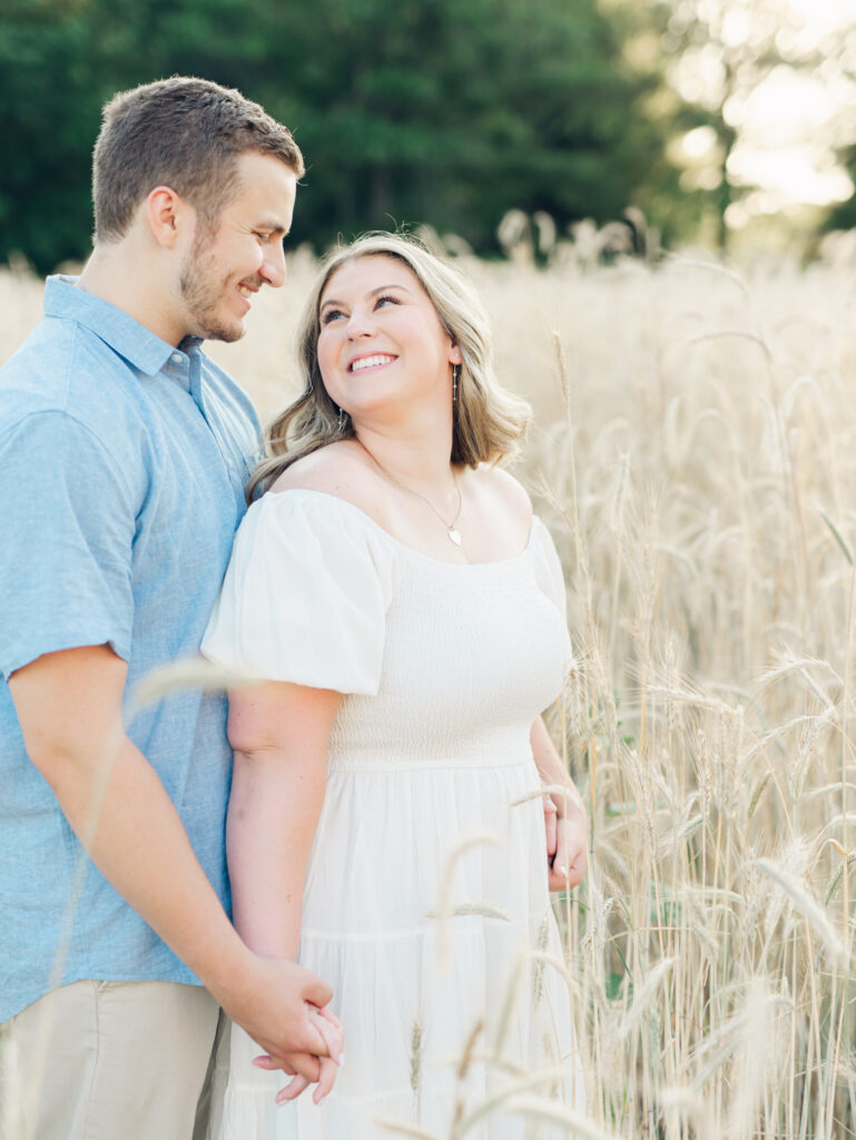 Casey and Giovanni laughing with each other in the fields at Bortner Valley during their engagement session