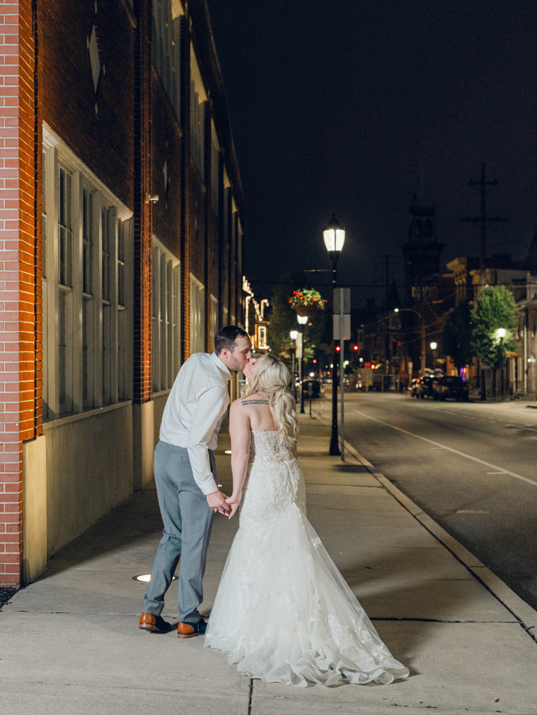 Amanda and Corey sharing a kiss outside of The Bond Events after sundown on their wedding day