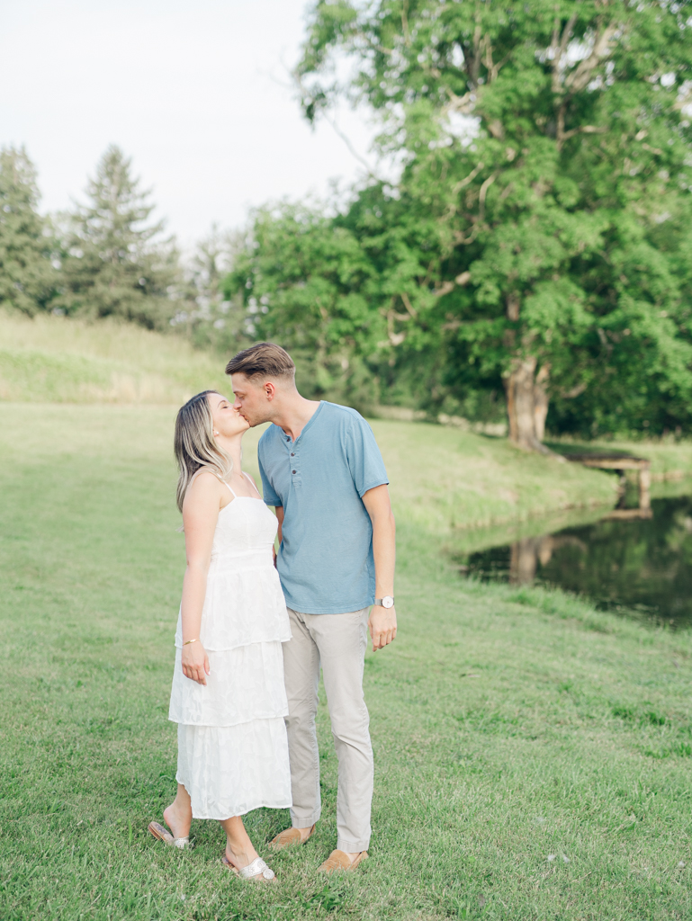 Victoria and Jacob kissing near the pond at Cold Saturday Farm
