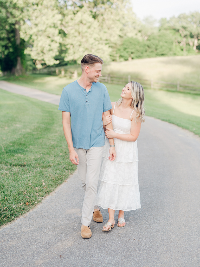 Victoria & Jacob walking along the driveway for their engagement session at Cold Saturday Farm