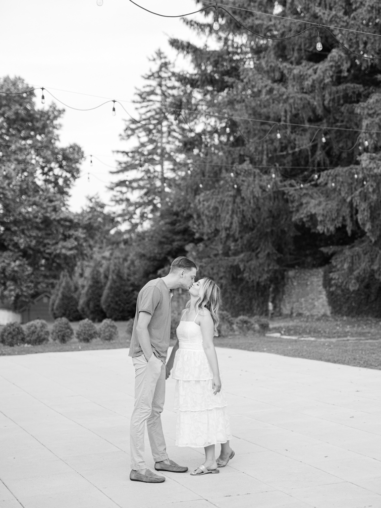 Victoria & Jacob sharing a kiss on the courtyard patio at Cold Saturday Farm during their engagement session. 