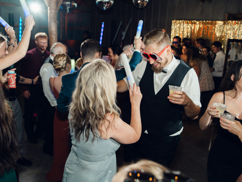 guests dancing at wedding reception with glow sticks