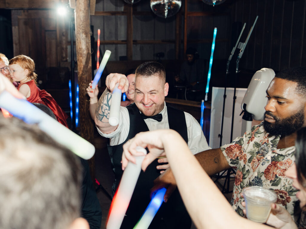 guests dancing at wedding reception with glow sticks