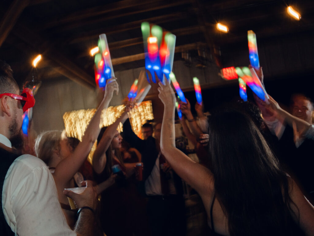 guests dancing at wedding reception with glow sticks