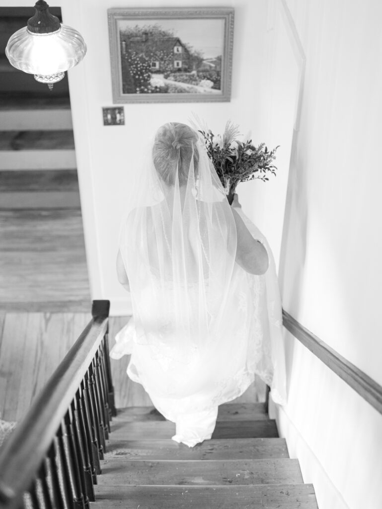 bride walking down stairs of manor house at The Hummingbird Chateau on her wedding day