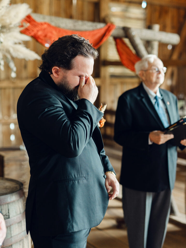 Groom getting emotional seeing his bride for the first time during his wedding ceremony at The Hummingbird Chateau