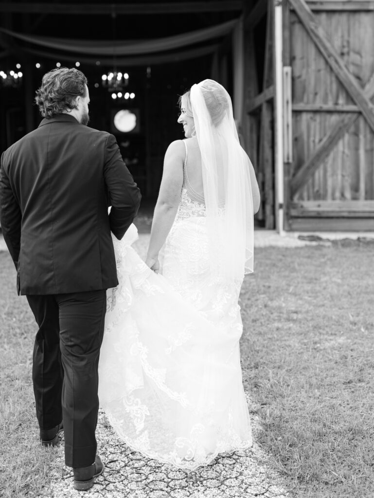 bride and groom walking outside of the barn at The Hummingbird Chateau wedding day