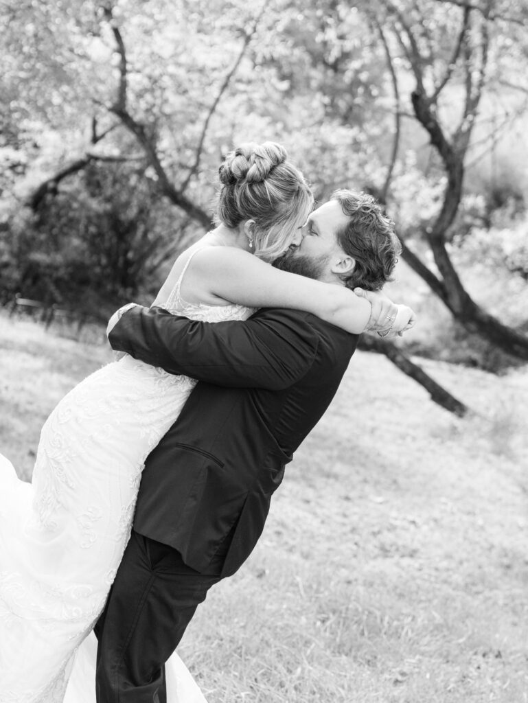 Bride and groom hugging and kissing each other on their wedding day at The Hummingbird Chateau 