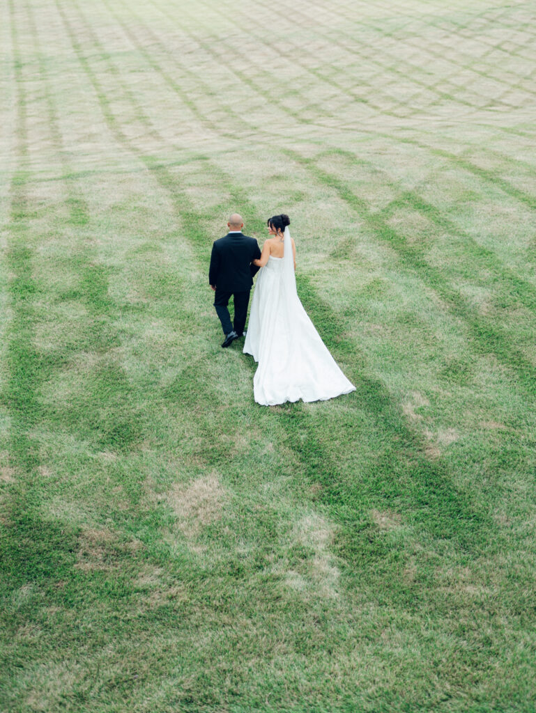 Bride and groom walking at Bortner Valley a Hampstead, MD wedding venue by Sunset Florals, Events by Stace, Nicole Simensky Photography.