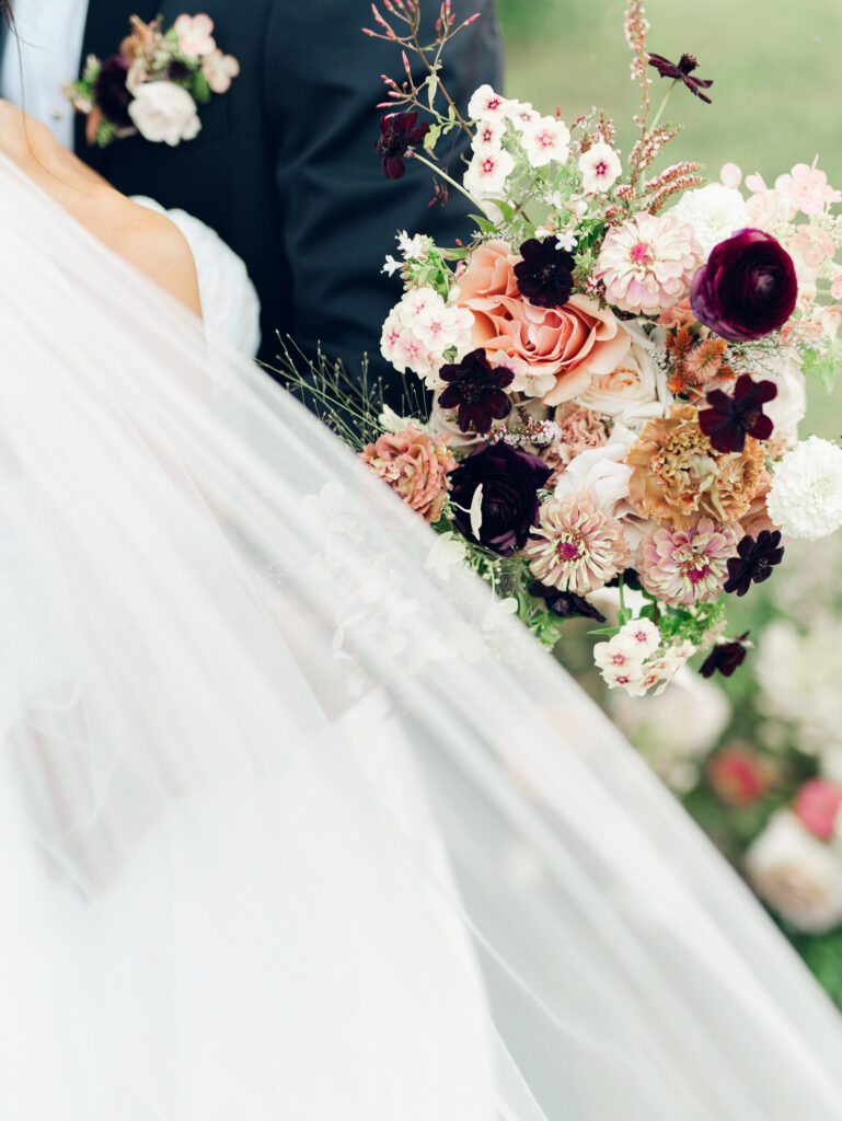 bridal bouquet with wedding veil flowing in the breeze. Bouquet by Sunset Florals