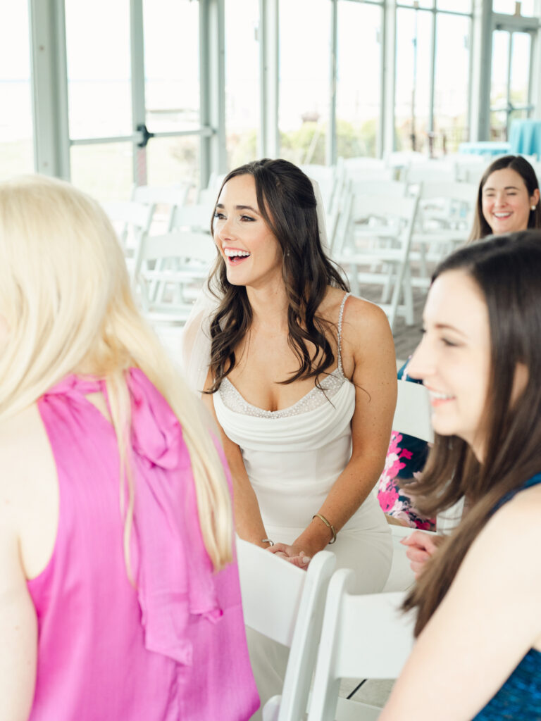 Bride smiling at something happening off camera on her wedding day by a Baltimore, MD documentary style wedding photographer