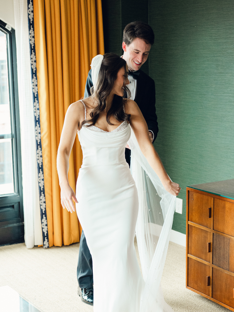 Bride showing groom her dress during their first look at the Graduate Hotel Annapolis
