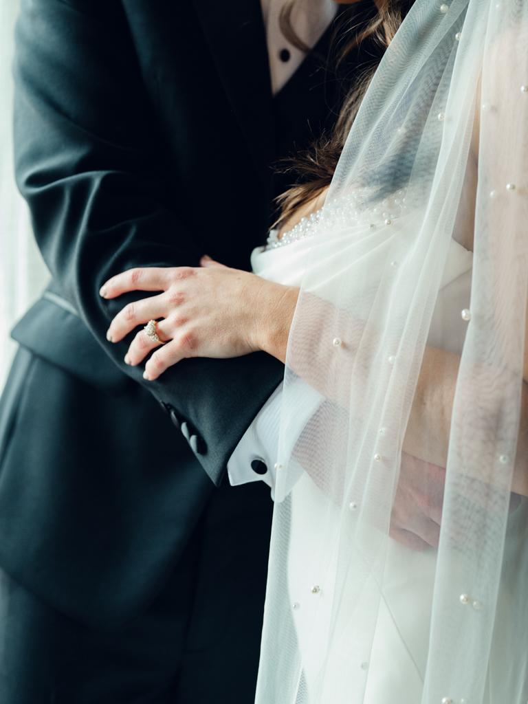 bride's engagement ring and pearl veil close up 