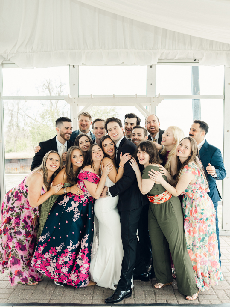 wedding party hugging and laughing with bride and groom on their wedding day at Silver Swan Bayside