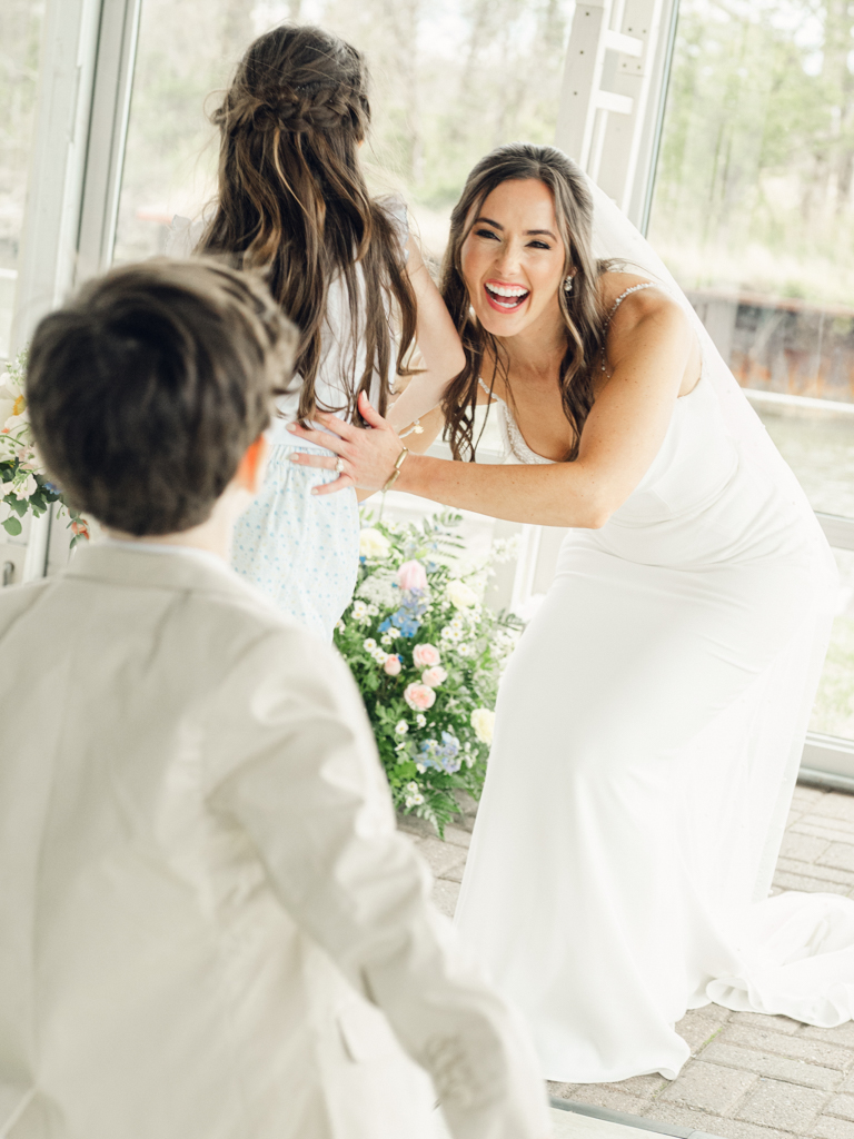 bride hugging her niece and nephew during her wedding day at Silver Swan Bayside