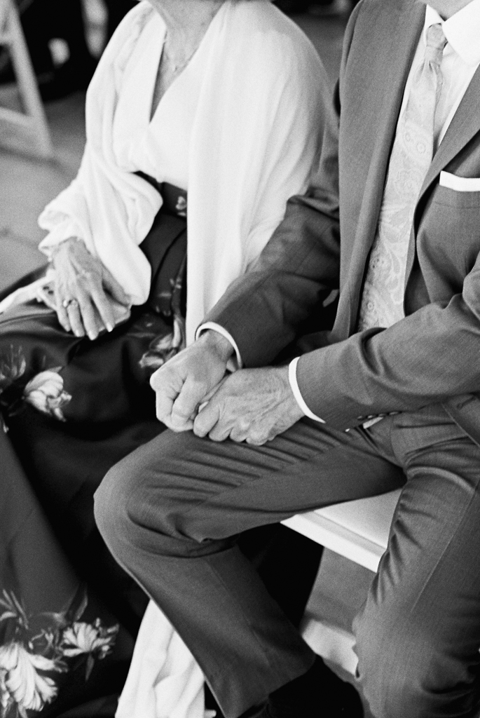 wedding guests holding hands during wedding ceremony taken by film wedding photographer