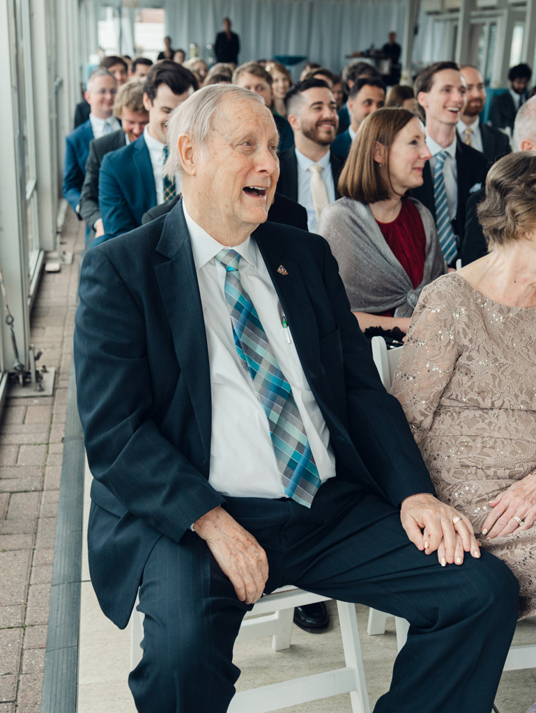 groom's grandfather laughing during the wedding ceremony
