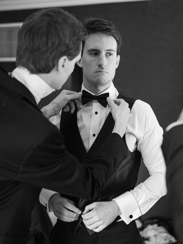 groom and his groomsmen helping him get ready before his first look at the Graduate Hotel Annapolis