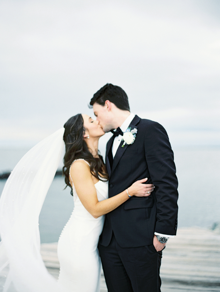 Bride and groom kissing outside on their wedding day taken by film wedding photographer
