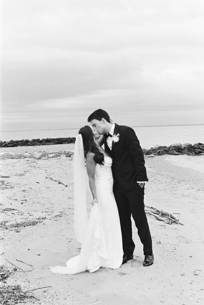 Bride and groom kissing on the beach at Silver Swan bayside on their wedding day taken by film wedding photographer