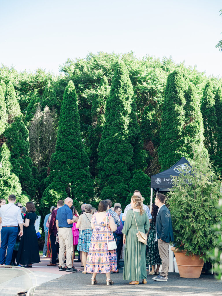 Guests enjoying cocktail hour outside at Swan Harbor Farm on the Bride and Groom's wedding day by a Baltimore, MD documentary style wedding photographer