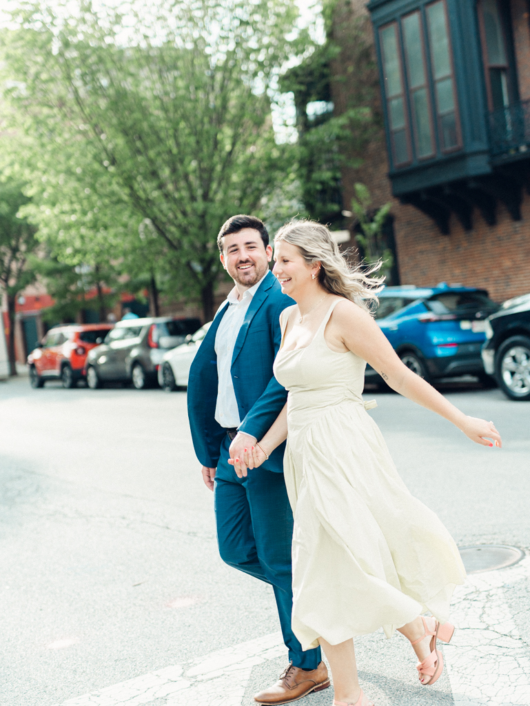couple smiling crossing the street in Mount Vernon Baltimore by Baltimore wedding photographer