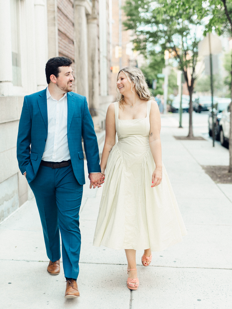 couple walking down sidewalk together in Mount Vernon Baltimore by Baltimore wedding photographer