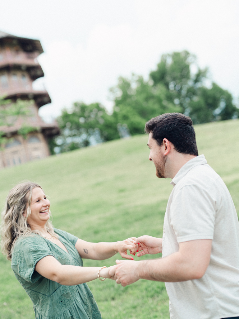 couple laughing and holding hands during their engagement photos in Patterson Park by Baltimore wedding photographer