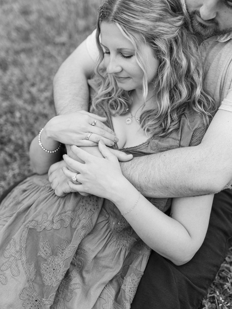 couple cuddling in the grass in Patterson Park by Baltimore wedding photographer