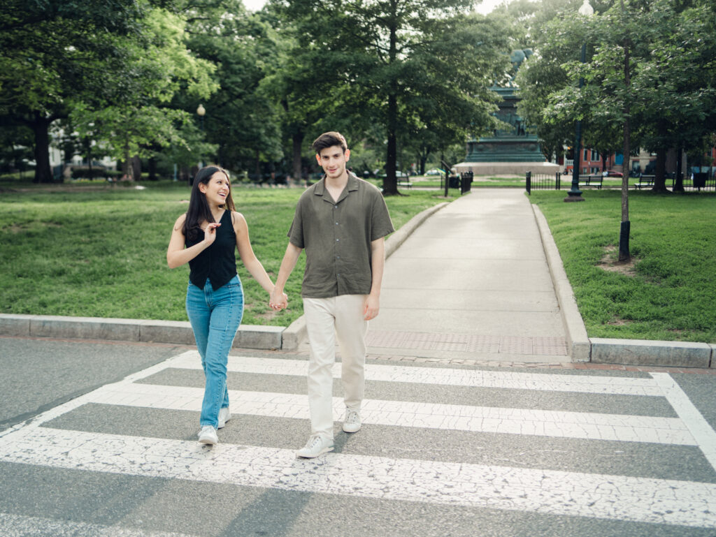couple crossing the street at Logan circle during their engagement session by dc film wedding photographer