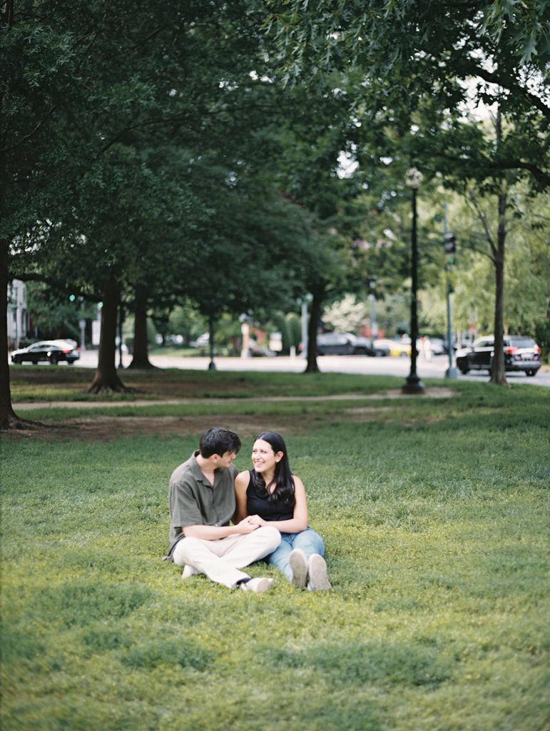 couple sitting together at Logan circle during their engagement session by dc film wedding photographer