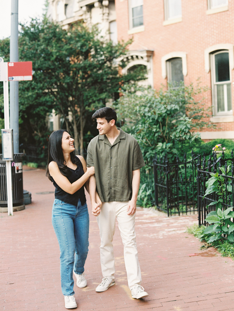 couple walking together at Logan circle during their engagement session by dc film wedding photographer