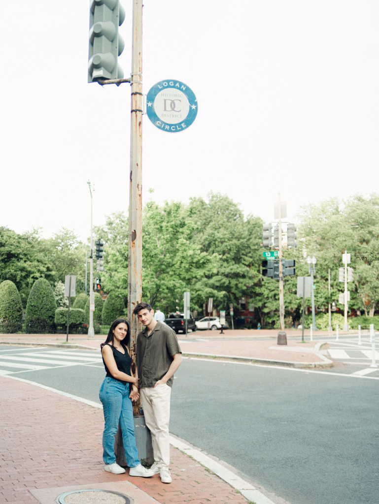 couple standing together at Logan circle during their engagement session by dc film wedding photographer