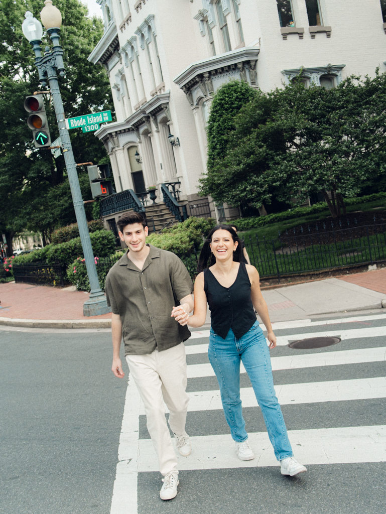 couple crossing the street at Logan circle during their engagement session by dc film wedding photographer