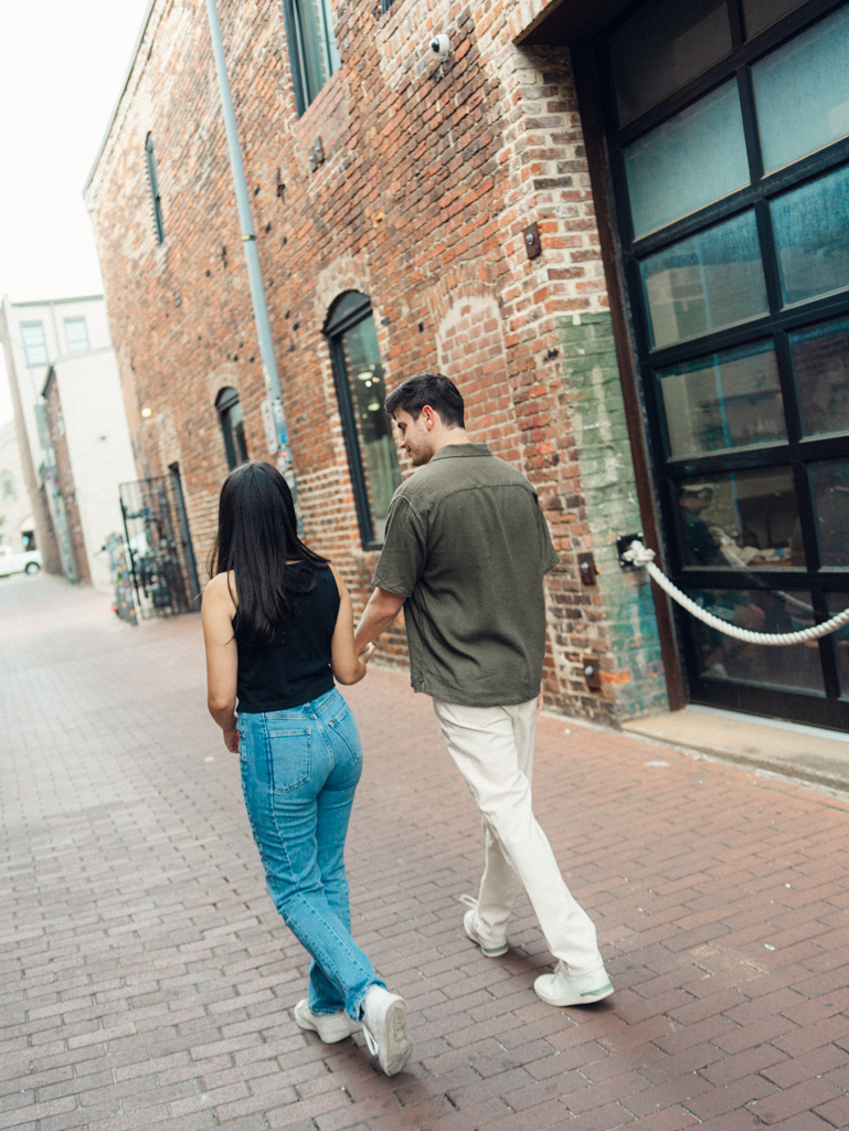 couple walking together during their engagement session in Blagden alley by dc film wedding photographer