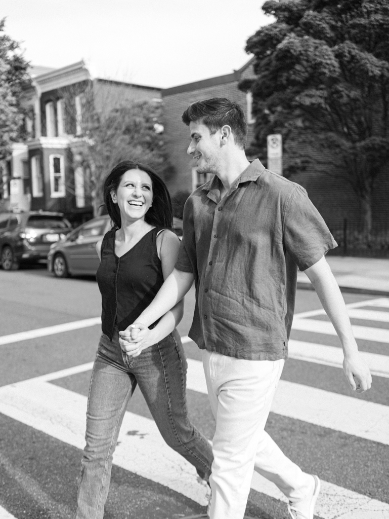 couple crossing the street during their engagement session in Blagden alley by dc film wedding photographer